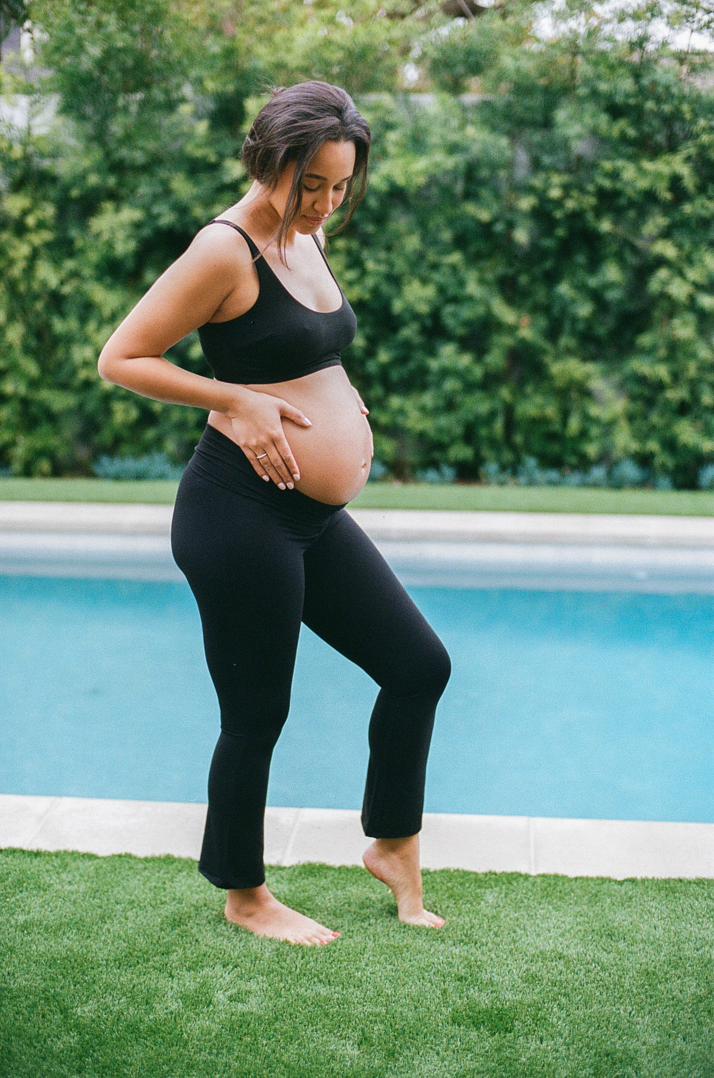 pregnant woman standing by pool