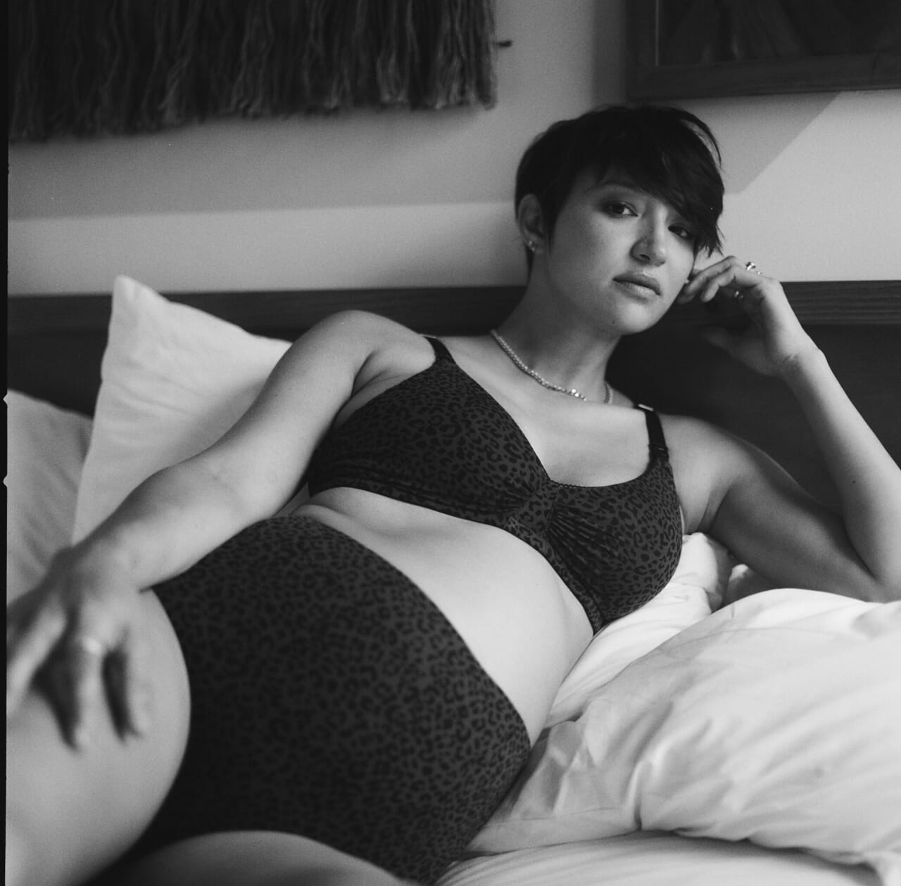 black and white photo of pregnant woman laying in bed