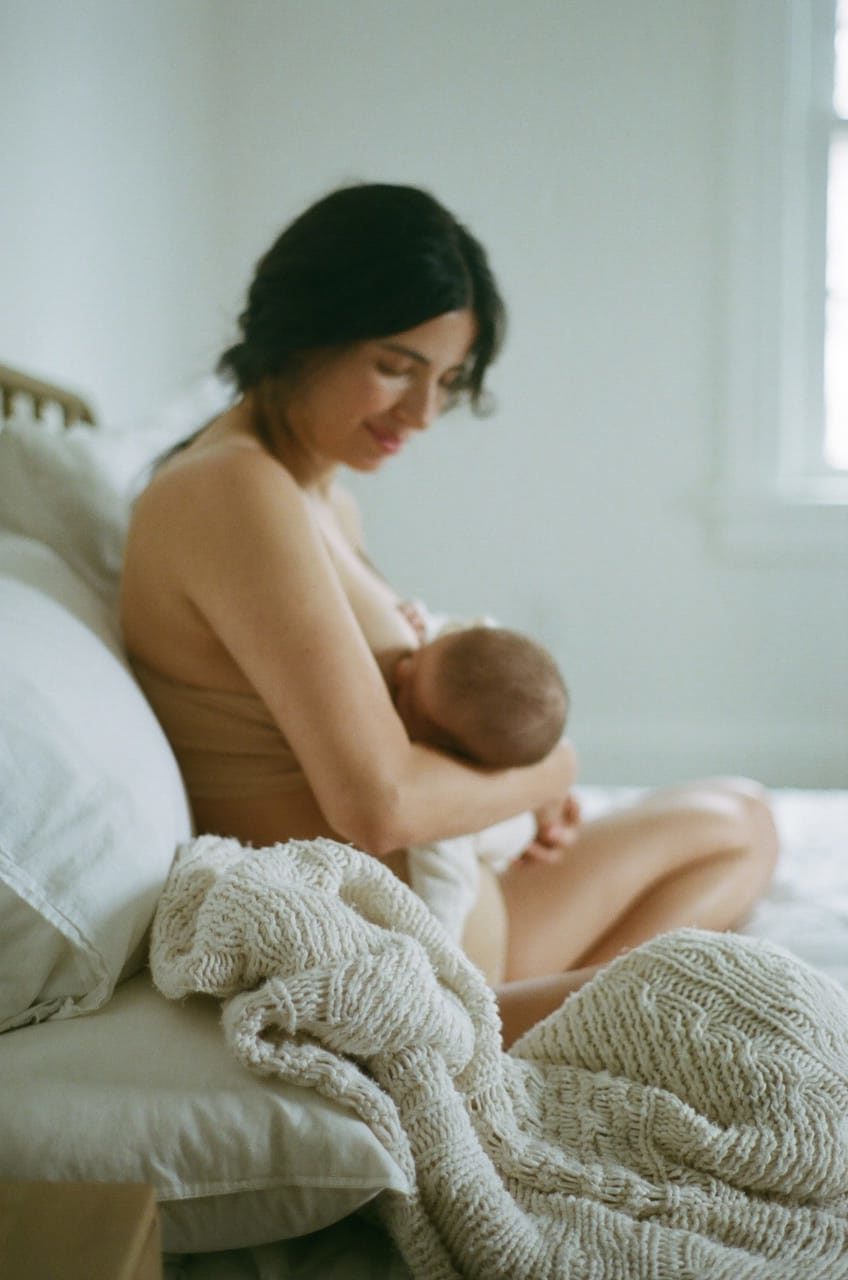 woman in bed holding baby