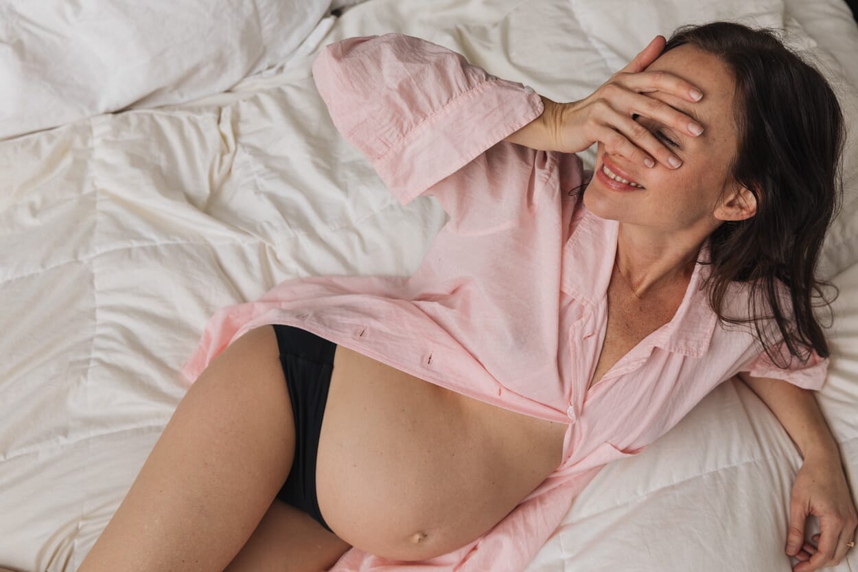 pregnant woman laying in bed