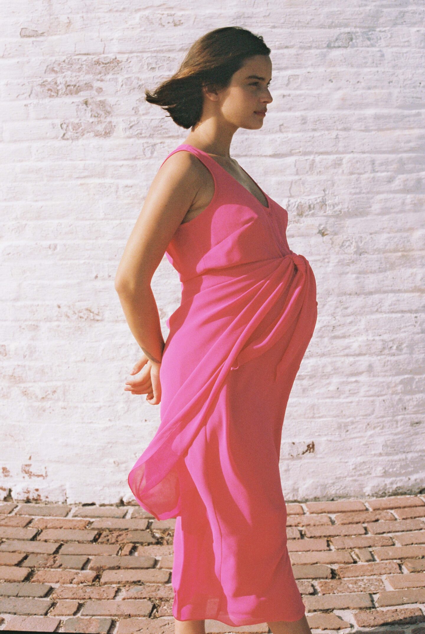 pregnant woman in profile wearing a pink dress
