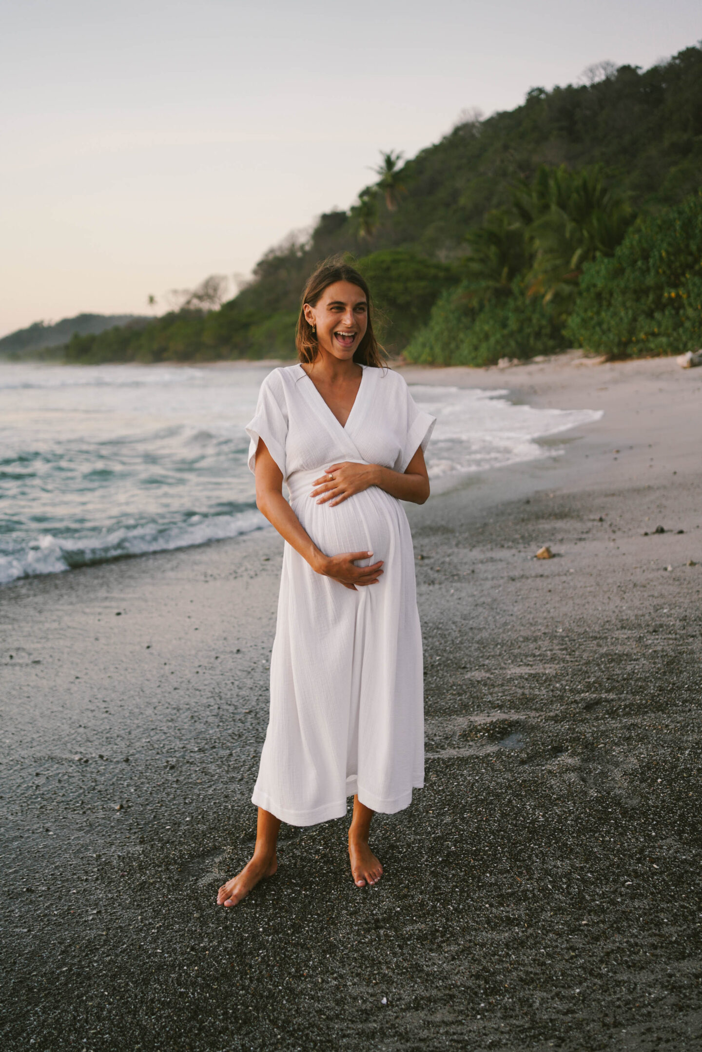 pregnant woman in white dress on the beach