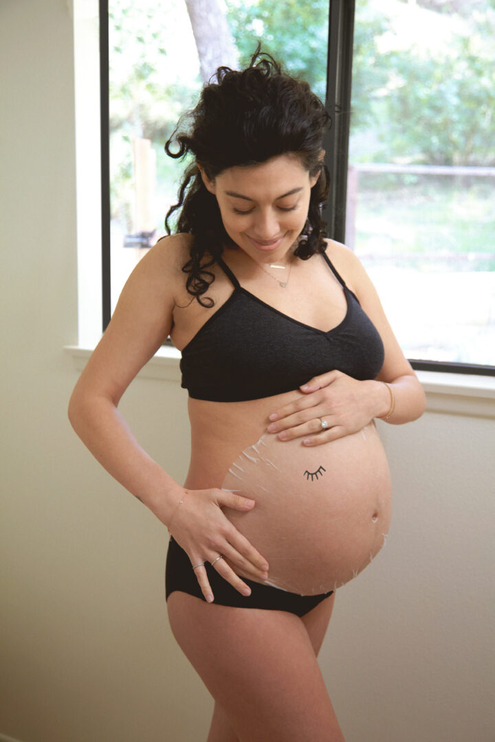 pregnant woman with a belly sheet mask on