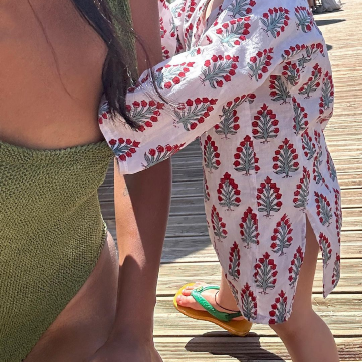 Baby pulling at mother's swimsuit to reach nipple