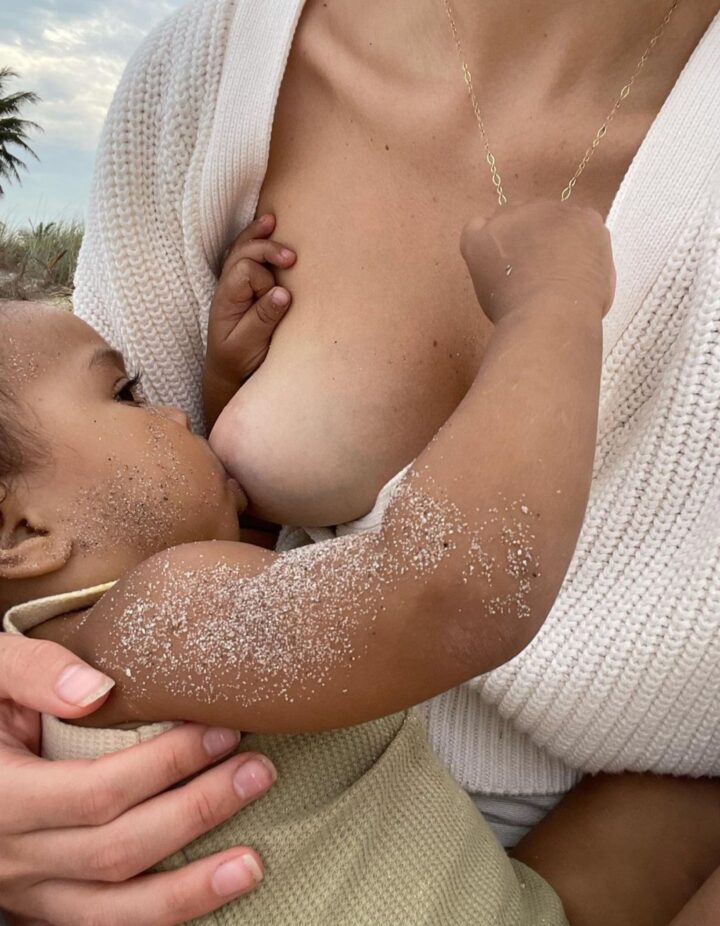 woman breastfeeding covered in sand
